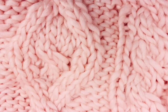 ピンク色のケーブル編みのニット